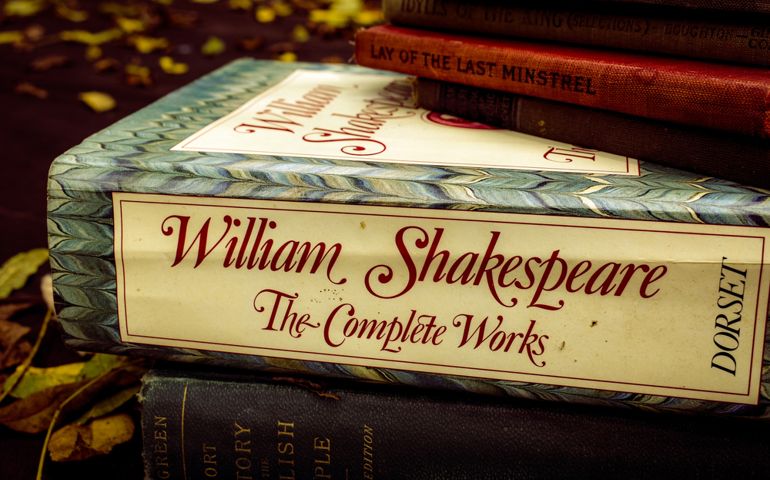 The Complete Works of William Shakespeare stacked in a pile of old vintage books for sale
