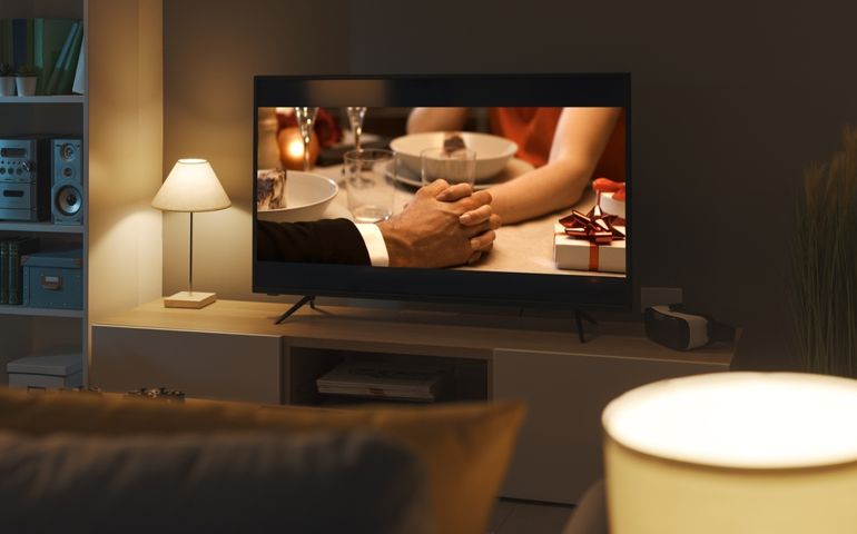 Romantic comedy movie streaming on TV and living room interior