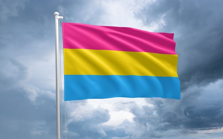 LGBTQIA+ Pansexual pride flag. Pansexuality flag symbol in the lgbt community. Dramatic storm clouds on the background