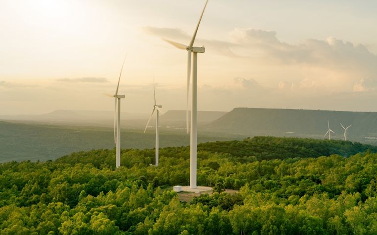 Selective focus on wind farm. Wind energy. Wind power. Sustainable, renewable energy. Wind turbines generate electricity. Windmill farm on mountain. Green technology. Sustainable resources.
