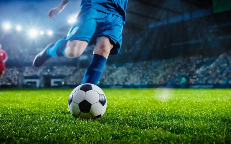 Football World Championship: Soccer Player Runs to Kick the Ball. Ball on the Grass Field of Arena, Full Stadium of Crowd Cheers. International Tournament. Cinematic Shot Captures Victory.