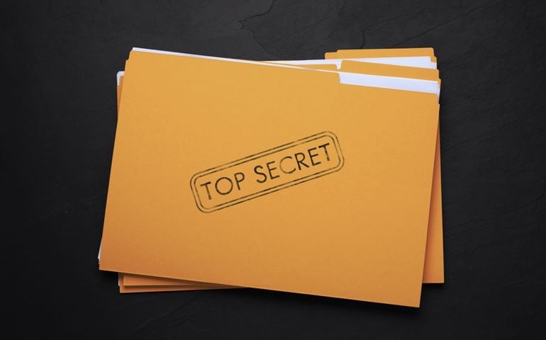 Yellow file with documents and Top Secret stamp on black table, top view