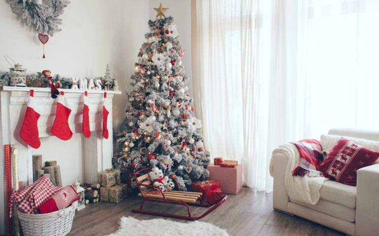 Beautiful holdiay decorated room with Christmas tree with presents under it