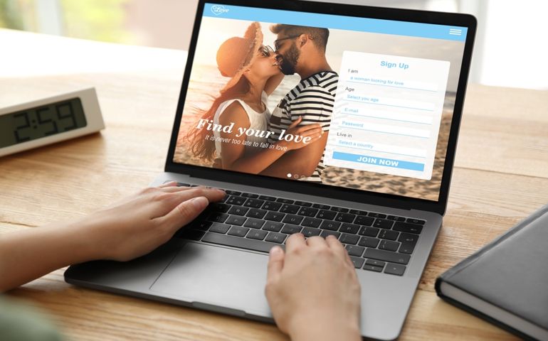 Looking for partner. Woman creating account on dating site via laptop, closeup