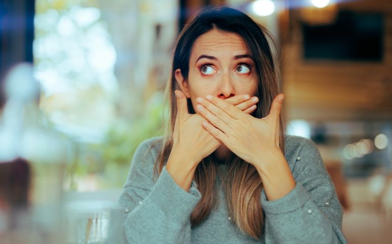 Burping Woman Covering her Mouth in a Restaurant Sick girl feeling nauseated and gassy after her meal