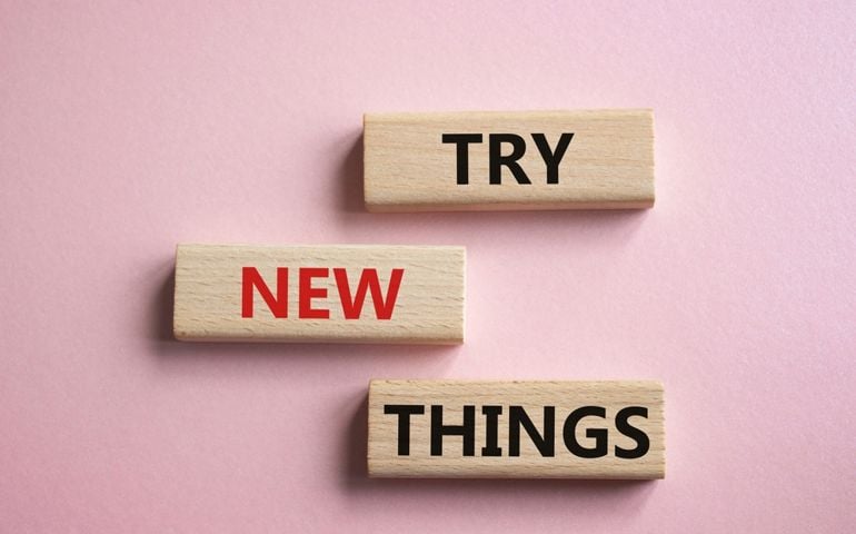 Try new Things symbol. Concept words Try new Things on wooden blocks. Beautiful pink background. Business and Try new Things concept. Copy space.