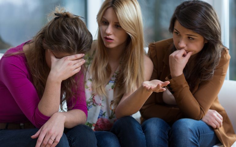 Young broken down woman and her helpful friends
