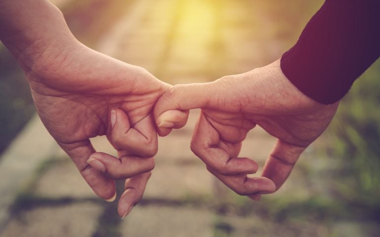 Valentine day background. Happy couple holding hands together as forever love. Vintage filter.