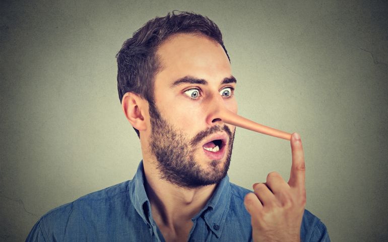 Man with long nose isolated on grey wall background. Liar concept. Human face expressions, emotions, feelings