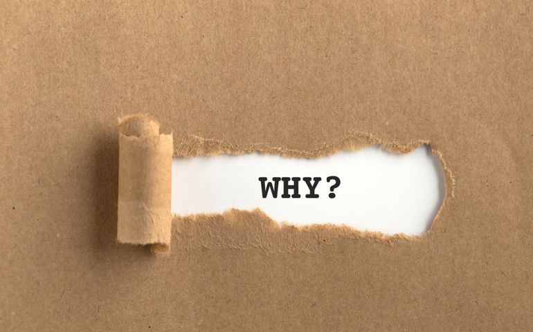 The text WHY? behind torn brown paper