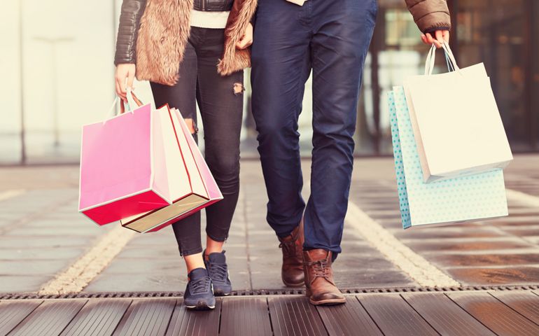 Midsection of couple with shopping bags in city