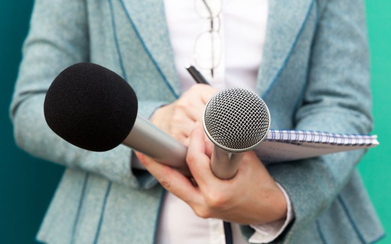 writing notes, holding microphone