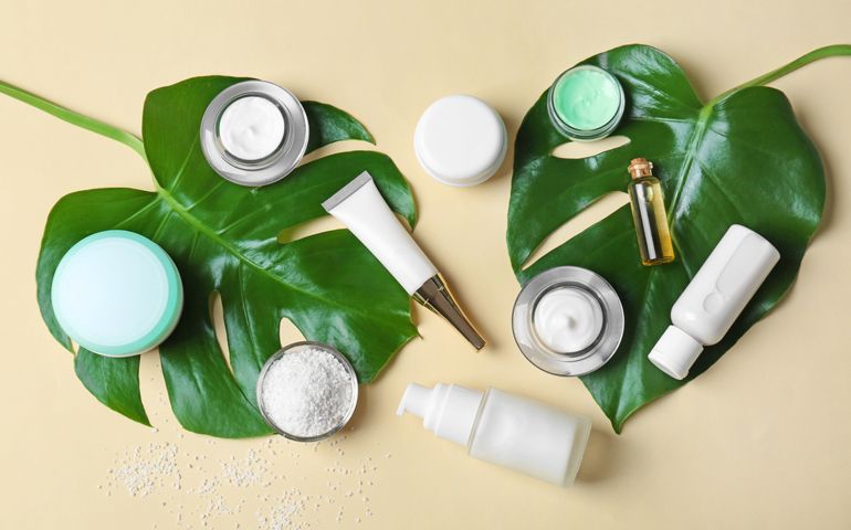 Natural cosmetics and leaves on light background