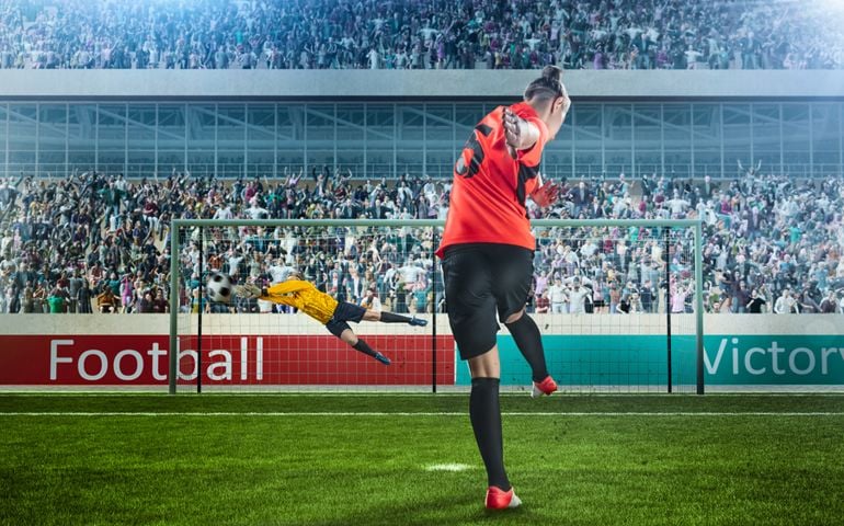 female soccer player taking penalty on crowded stadium