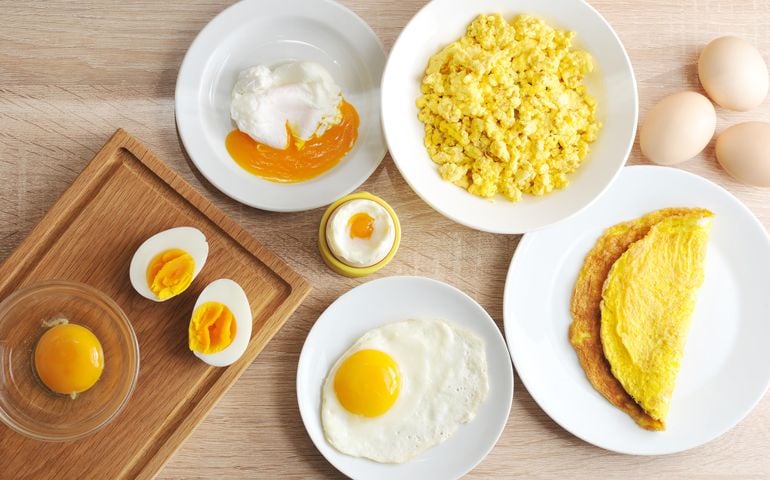 Various ways of cooking chicken eggs. Omelette, poached, soft-boiled, hard-boiled, fried, scrambled eggs. Top view. Close-up.
