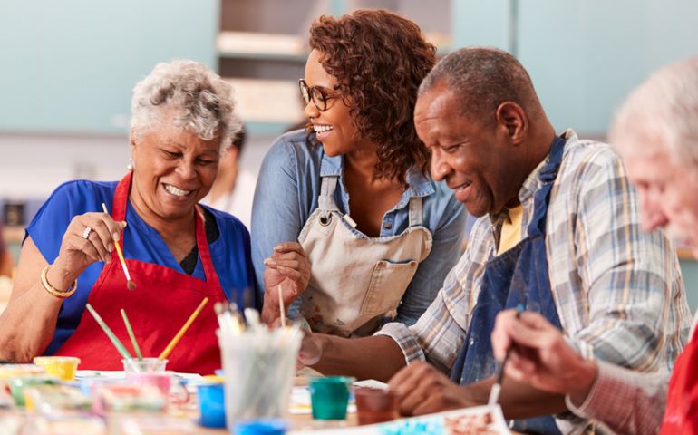 Group Of Retired Seniors Attending Art Class In Community Centre With Teacher