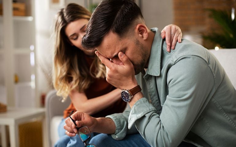 Young man having a problem. Girlfriend comforting her sad boyfriend.