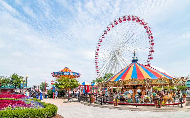 Chicago, Illinois, USA - August 24, 2014: Tourists at the amusement park on Navy Pier. Navy Pier's Ferris wheel.