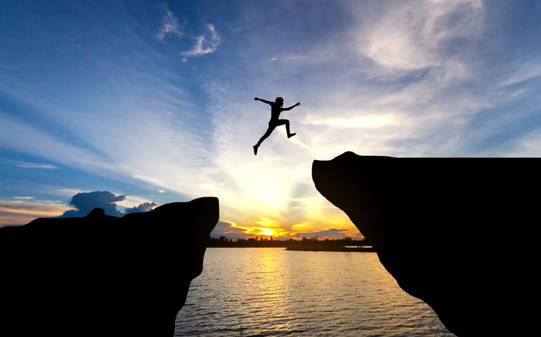 Man jump through the gap between hill.man jumping over cliff
