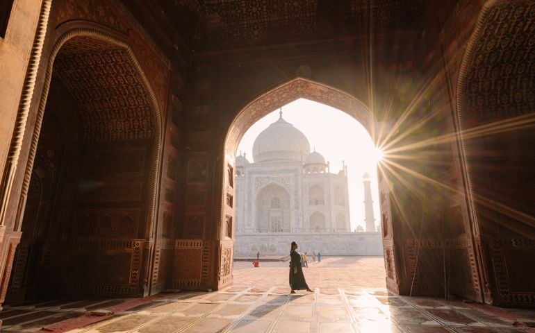 tourist standing in front entrance gate of Taj Mahal indian palace