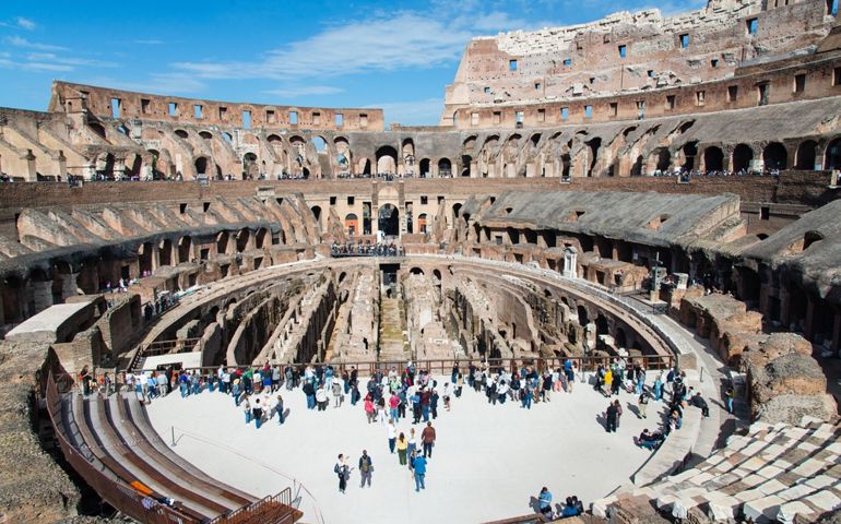 Tourists exploring the interior of the Colosseum on a sunny day