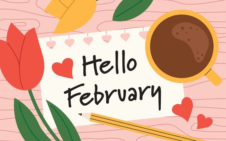 A coffee cup, red and yellow tulips, a pencil, and red paper hearts surround a handwritten card that says “Hello February”—a cheerful nod to the month’s mix of cozy rituals and celebrations.